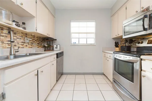 a kitchen with granite countertop a stove a sink and a microwave