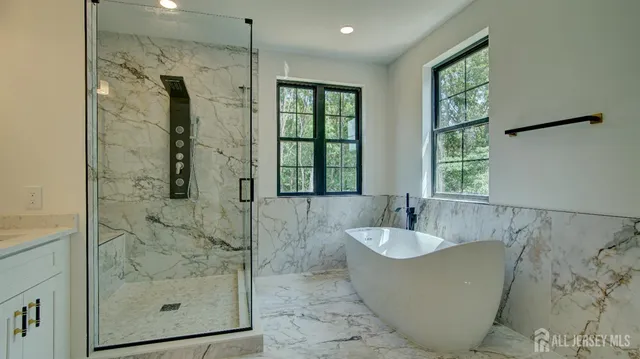 a large kitchen with kitchen island a large window a sink stainless steel appliances and cabinets