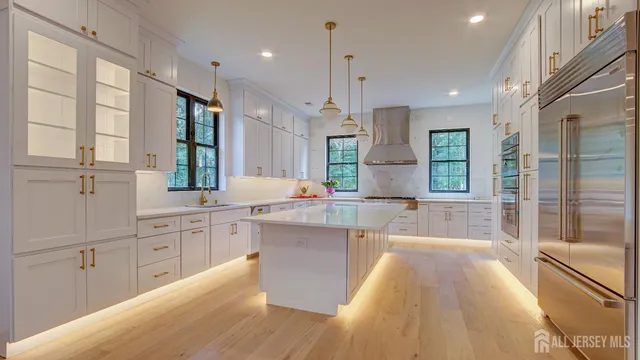 a kitchen with kitchen island granite countertop a sink a counter top space stainless steel appliances and cabinets