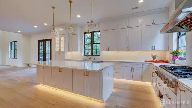 a kitchen with kitchen island granite countertop a stove a sink a center island and cabinets