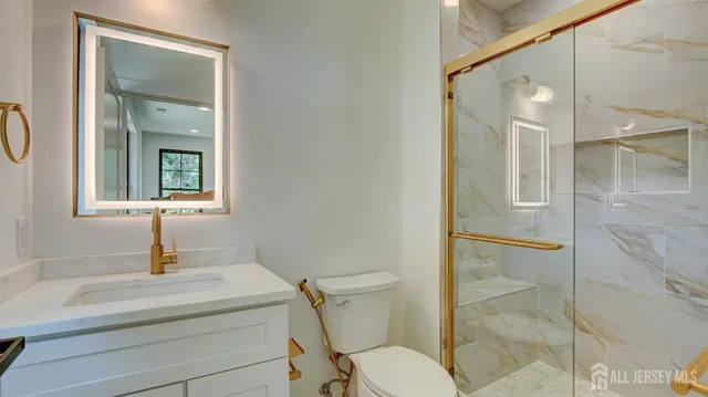 a bathroom with a sink a toilet and a mirror