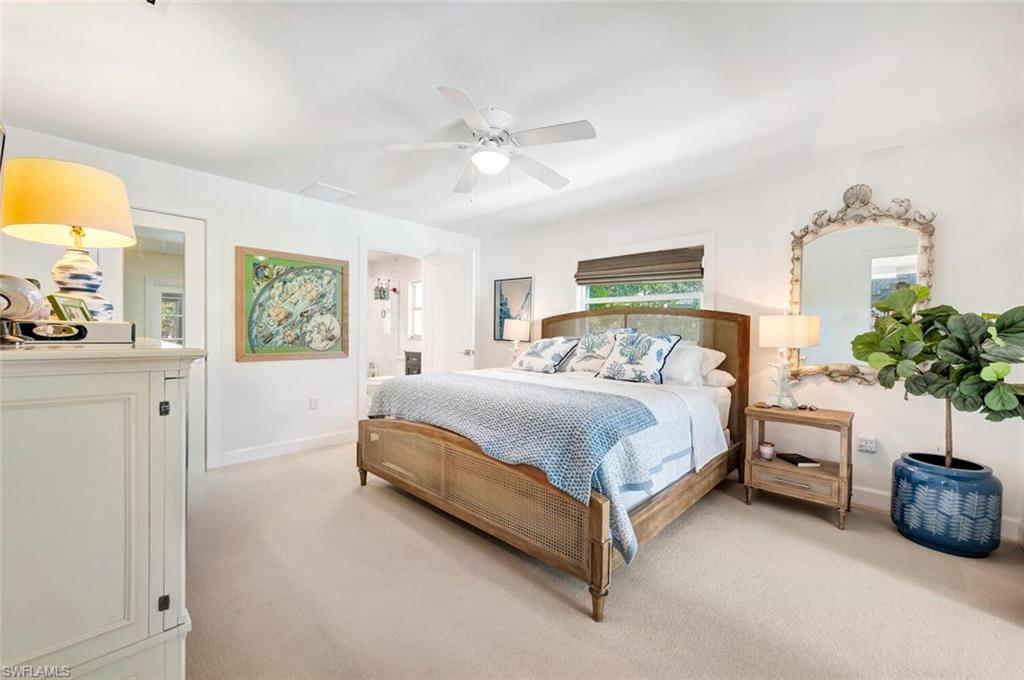 200 Burning Tree Drive Naples, FL 34105 - Photo 17 of 48 a spacious bedroom with a bed and a chandelier