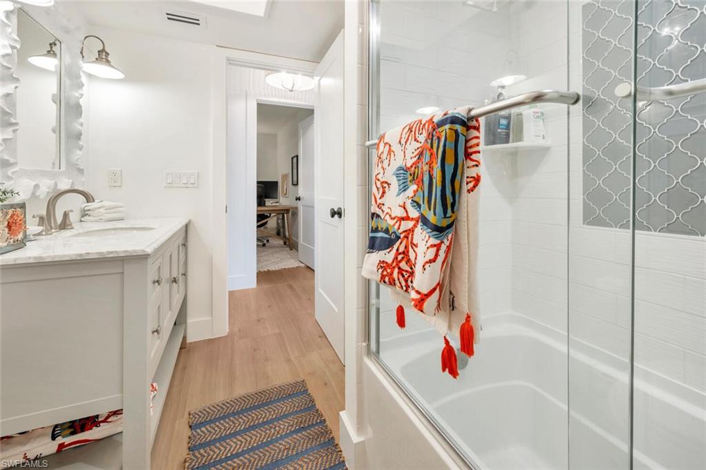 200 Burning Tree Drive Naples, FL 34105 - Photo 25 of 48 a bathroom with a sink a mirror and shower