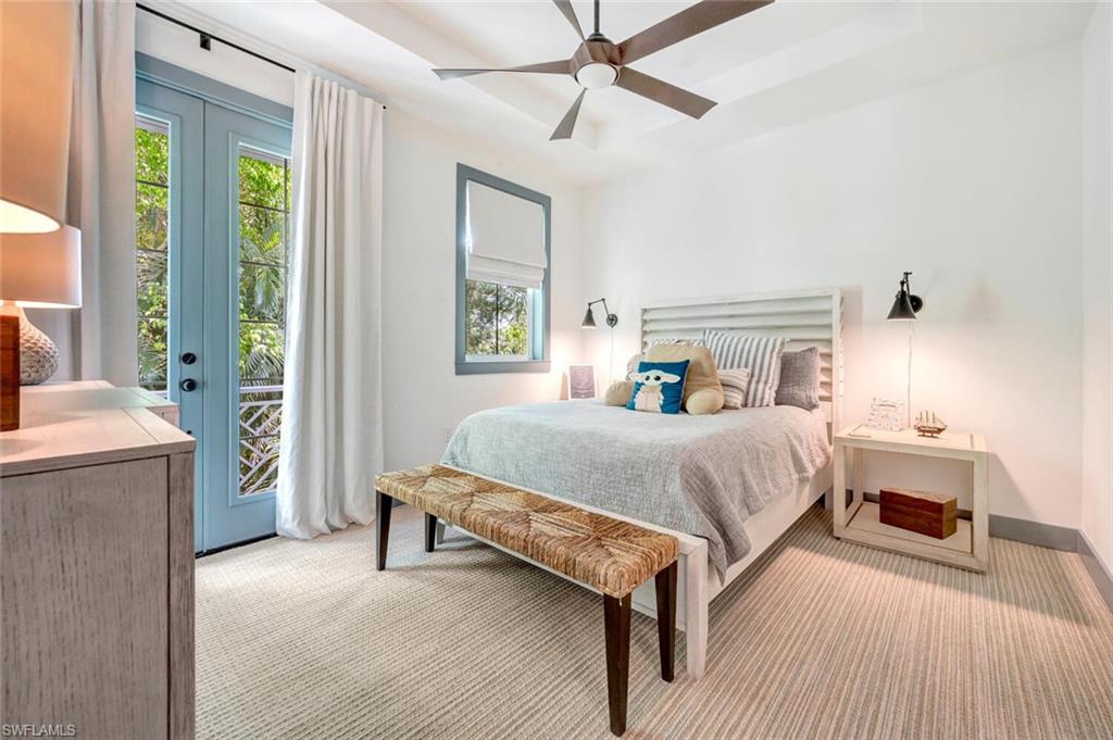 200 Burning Tree Drive Naples, FL 34105 - Photo 33 of 48 a bedroom with a bed and a chandelier