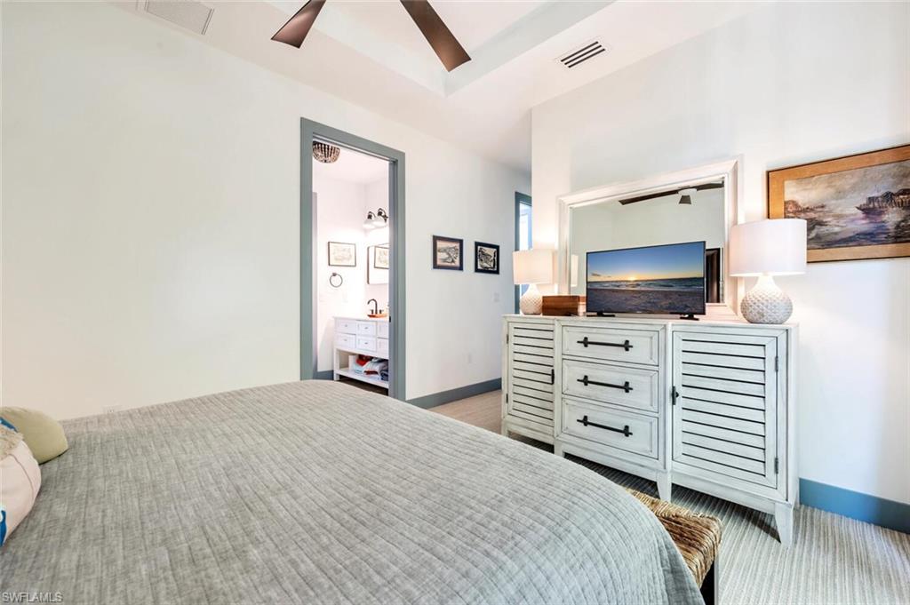 200 Burning Tree Drive Naples, FL 34105 - Photo 34 of 48 a bedroom with a bed and flat screen tv