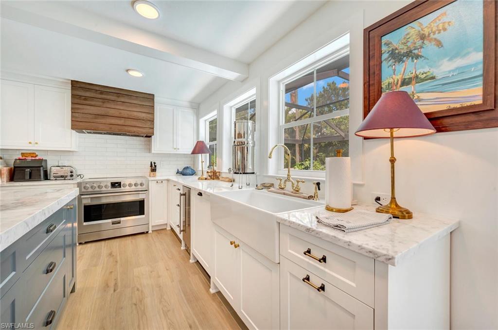 200 Burning Tree Drive Naples, FL 34105 - Photo 6 of 48 a kitchen with a sink stove and cabinets