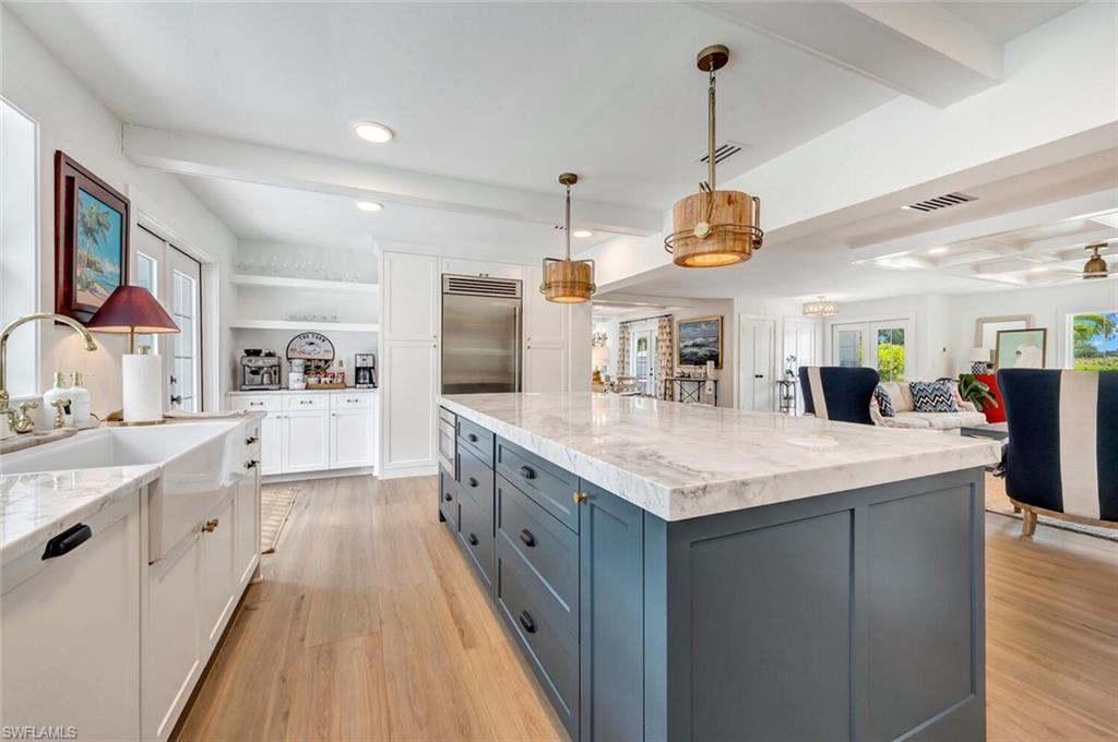 200 Burning Tree Drive Naples, FL 34105 - Photo 7 of 48 a kitchen with stainless steel appliances kitchen island granite countertop a sink a stove top oven a chimney and a center island
