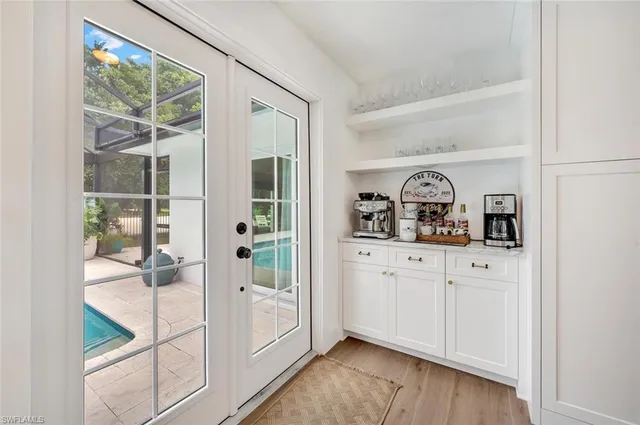 a kitchen with stainless steel appliances kitchen island granite countertop a table chairs sink and cabinets