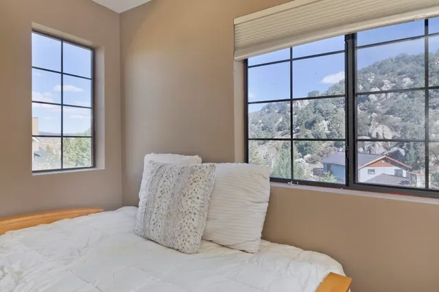 a view of a room that has a bed and a large window with outer view