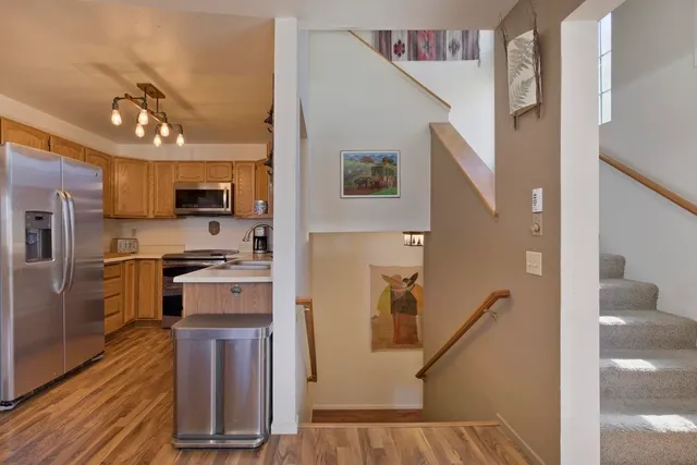 a kitchen with a refrigerator a stove top oven and wooden floor