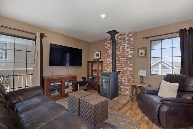 a living room with furniture a flat screen tv and large window