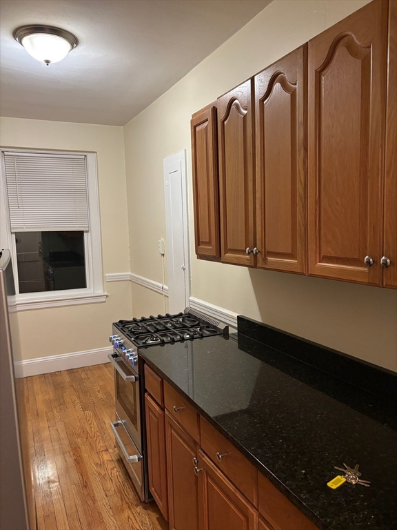 50 Broadway, Unit 47 Beverly, MA 01915 - Photo 3 of 10 a kitchen with granite countertop a sink and a stove top oven