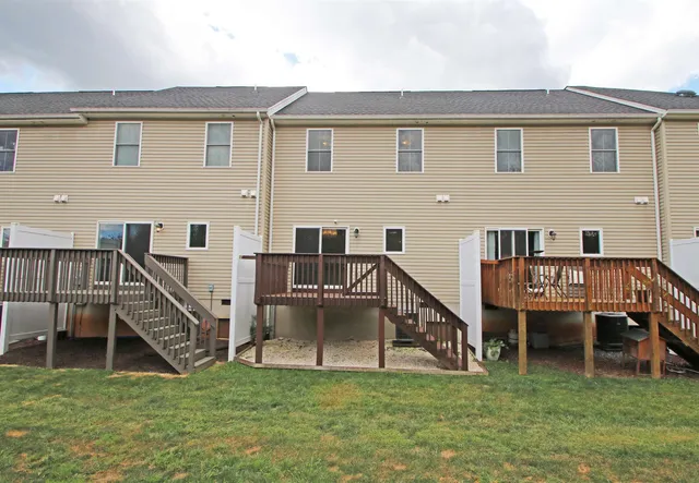 a view of a house with a yard and a deck