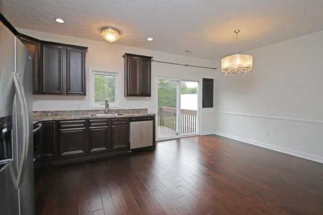 a kitchen with stainless steel appliances granite countertop a stove a sink and a refrigerator