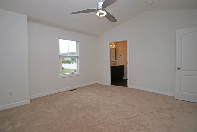 an empty room with a ceiling fan and a window