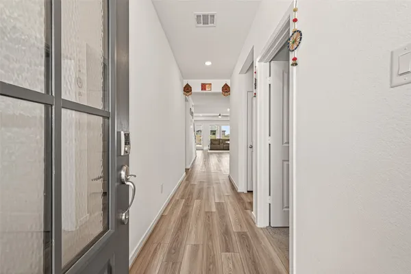 a view of a hallway with wooden floor and staircase
