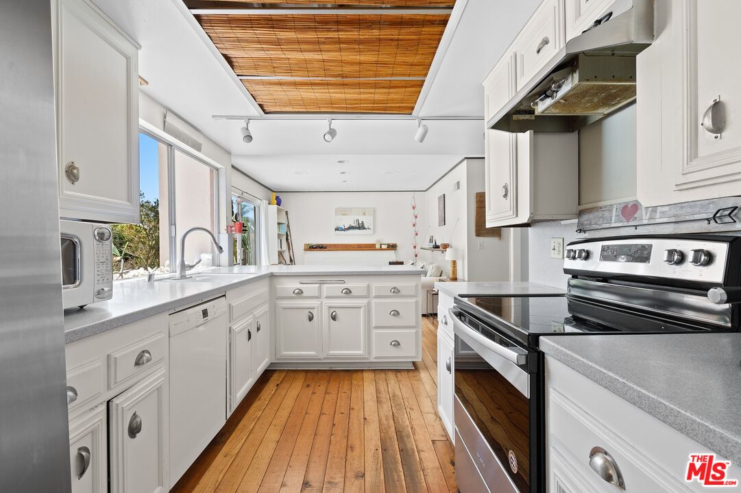 5101 Lindblade Drive Culver City, CA 90230 - Photo 4 of 11 a kitchen with granite countertop stainless steel appliances sink and cabinets
