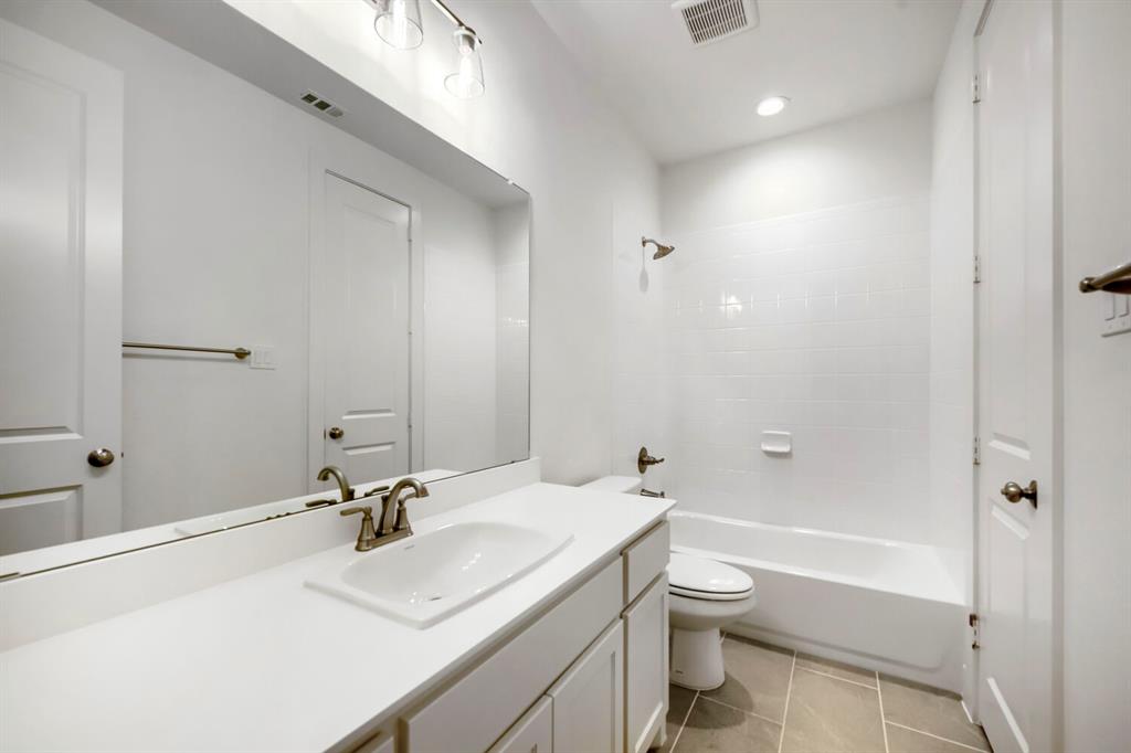 11548 Wulstone Road Haslet, TX 76052 - Photo 20 of 26 Bathroom featuring a white vanity with an integrated sink, brushed nickel faucet, and a wall-mounted mirror