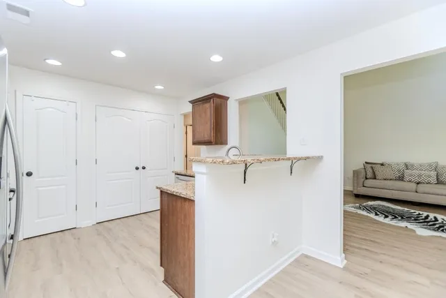 a view of a living room with kitchen appliances