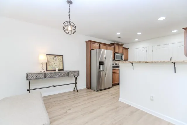 a view of a kitchen with a refrigerator and a wooden floor