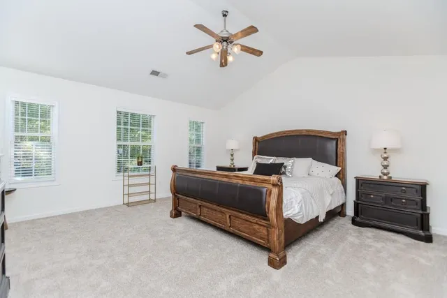 a bed sitting in a bedroom next to a window and a chandelier