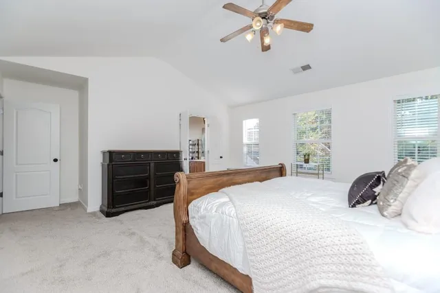 a bedroom with a bed dresser and a window