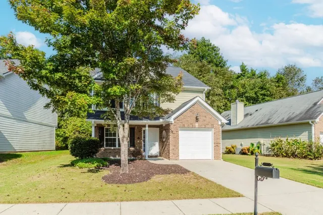 a front view of a house with a yard and garage