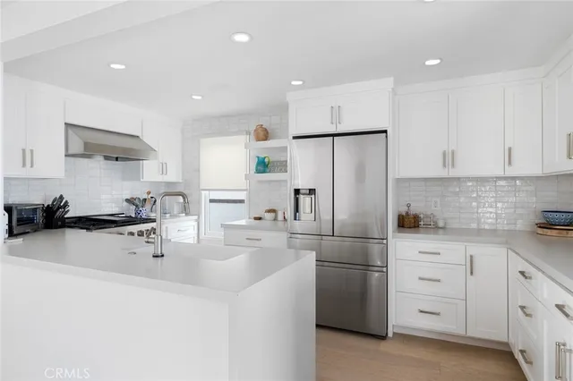 a kitchen with white cabinets and stainless steel appliances