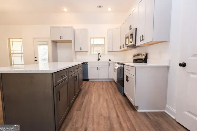 a kitchen with white cabinets appliances and sink