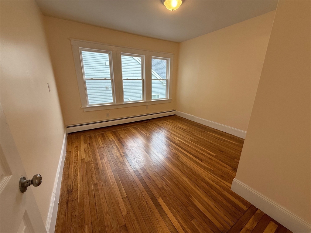 11 Dalrymple Street, Unit 3 Boston, MA 02130 - Photo 6 of 13 an empty room with wooden floor and windows