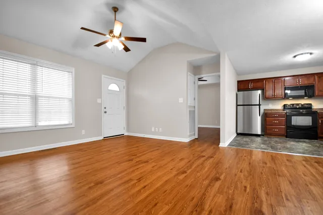 a view of a kitchen with a stove cabinets wooden floor and a ceiling fan