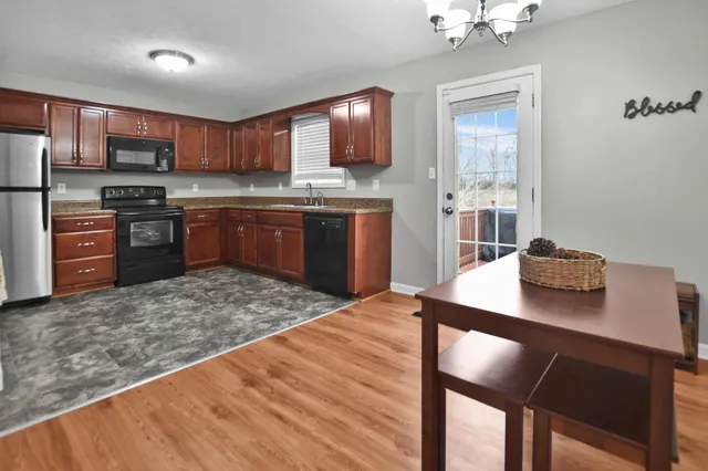 a kitchen with stainless steel appliances kitchen island granite countertop a refrigerator stove top oven and sink