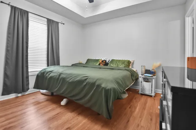 a bedroom with a bed and wooden floor