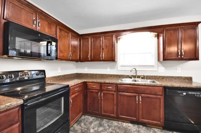 a kitchen with stainless steel appliances granite countertop a stove a sink and a microwave