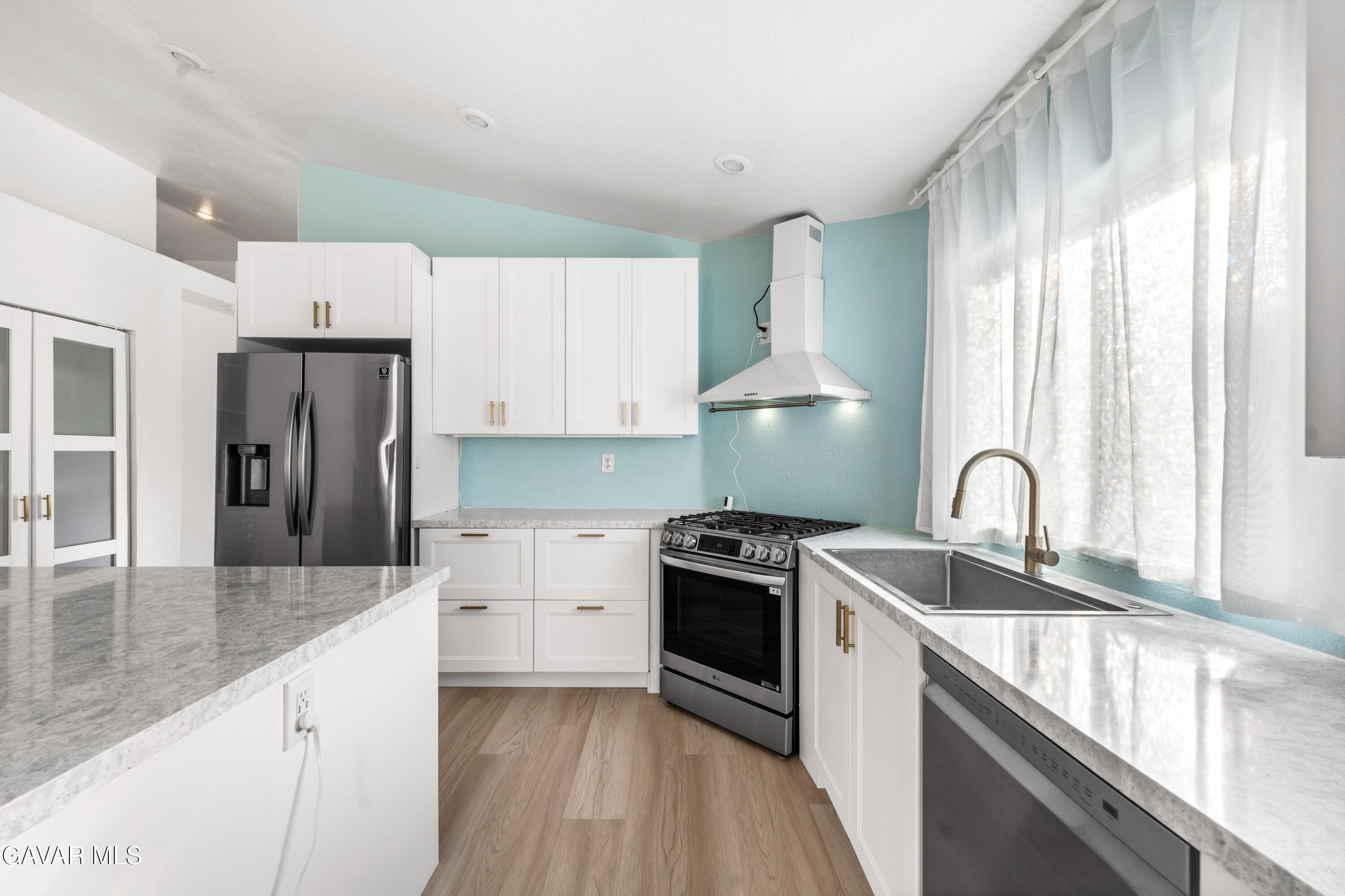 1639 East Kettering Street Lancaster, CA 93535 - Photo 11 of 35 a kitchen with granite countertop a sink stove and refrigerator
