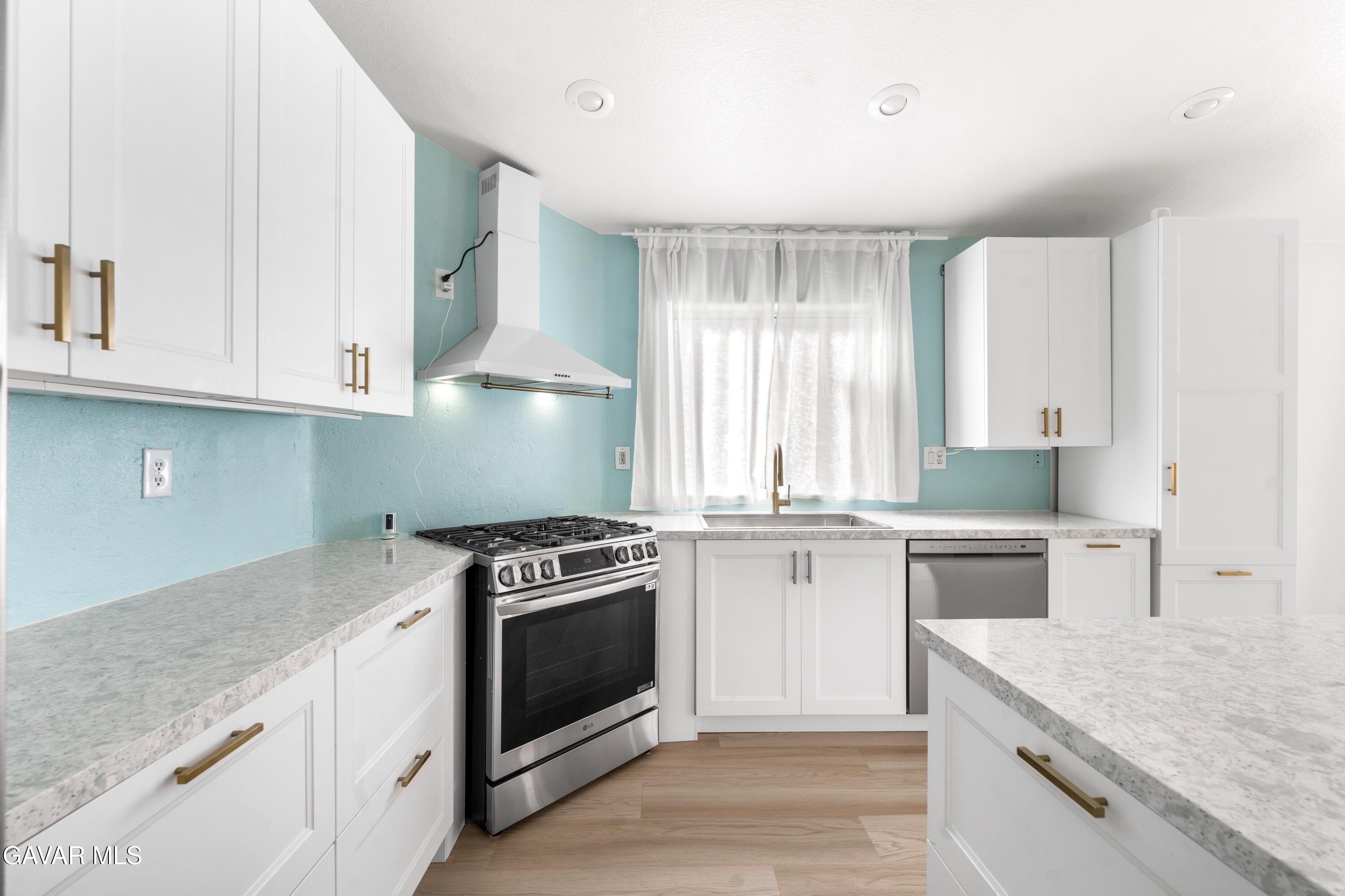 1639 East Kettering Street Lancaster, CA 93535 - Photo 15 of 35 a kitchen with a stove top oven sink and cabinets