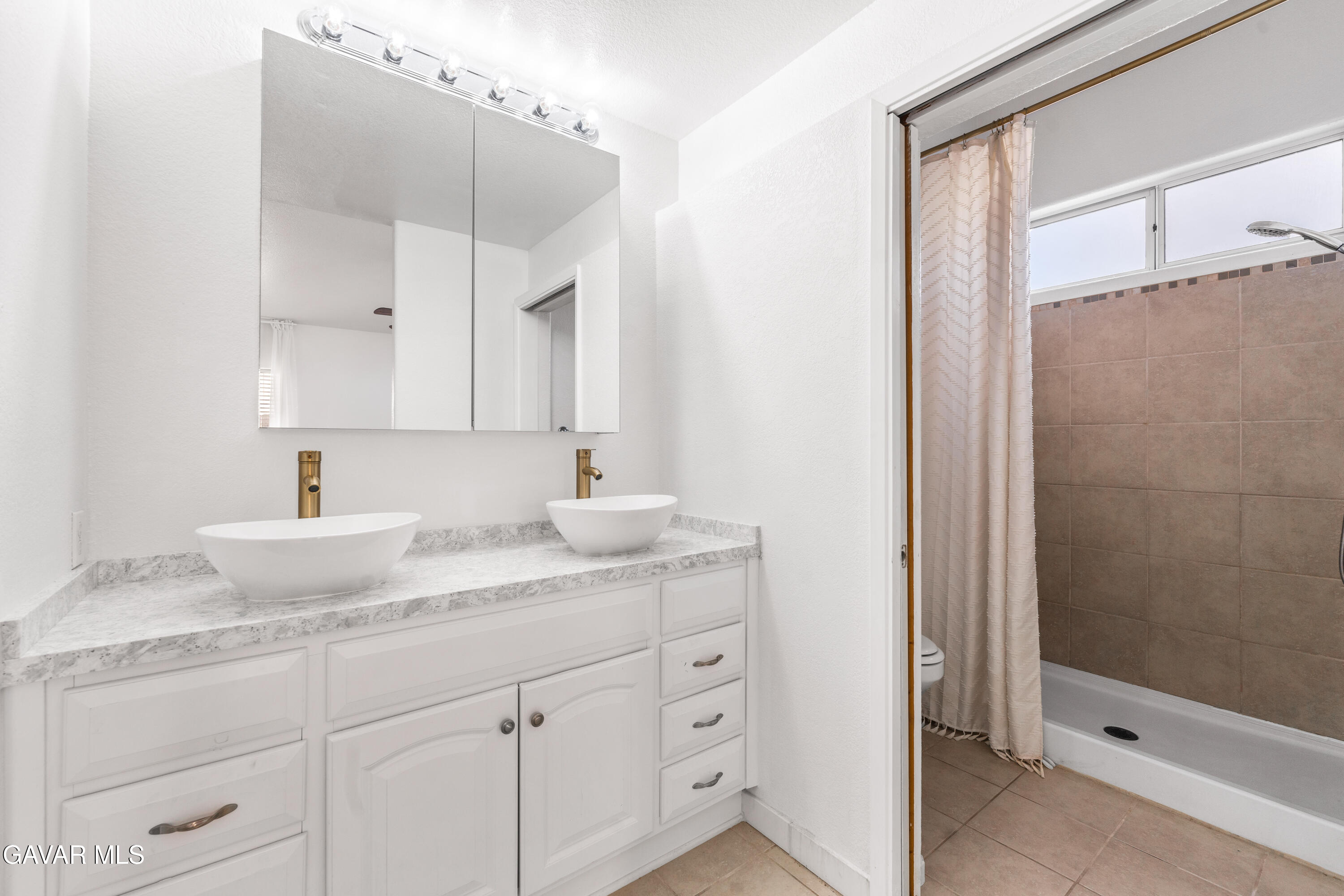 1639 East Kettering Street Lancaster, CA 93535 - Photo 25 of 35 a bathroom with a granite countertop sink two mirror and shower