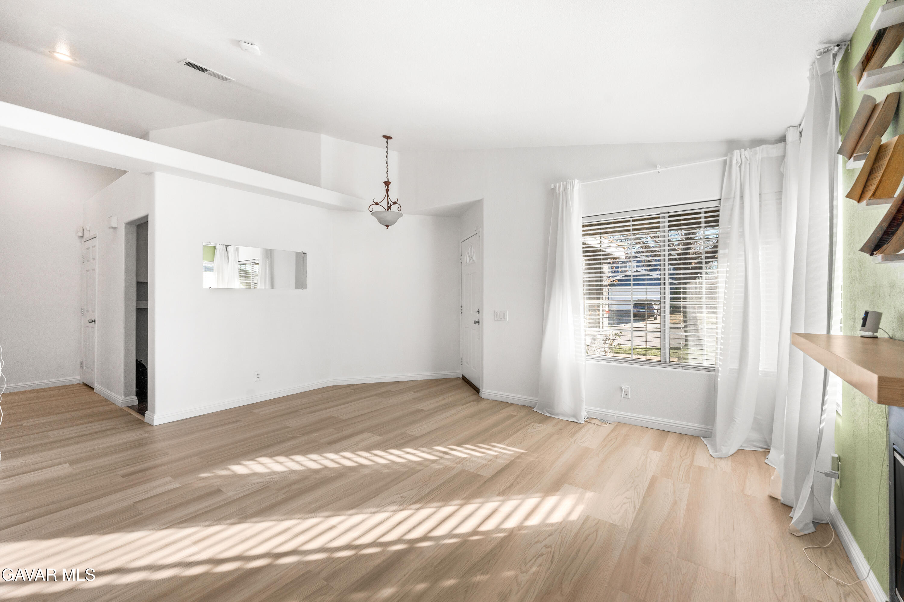 1639 East Kettering Street Lancaster, CA 93535 - Photo 7 of 35 a view of an empty room with a window and wooden floor