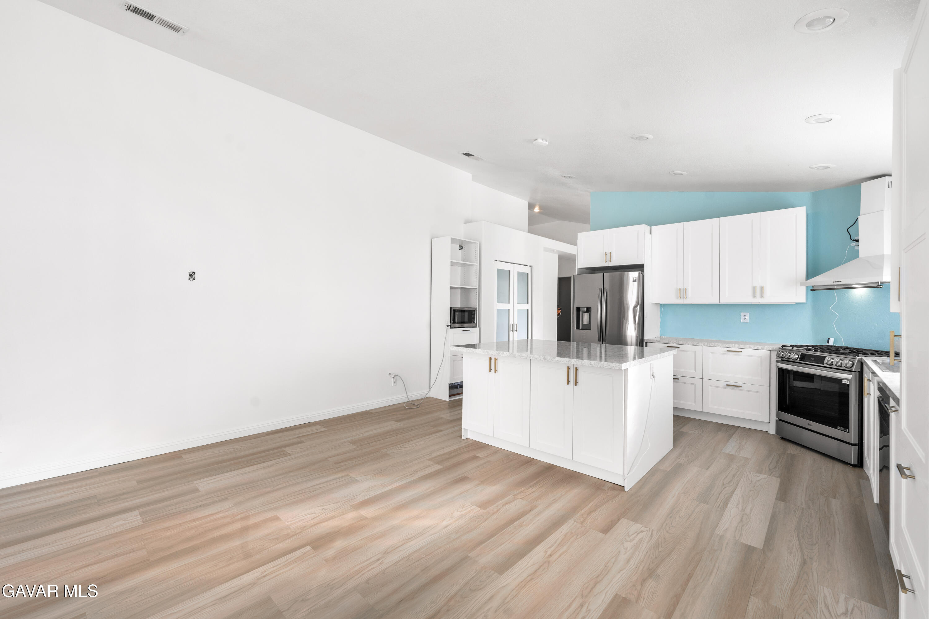1639 East Kettering Street Lancaster, CA 93535 - Photo 10 of 35 a kitchen with granite countertop white cabinets and stainless steel appliances