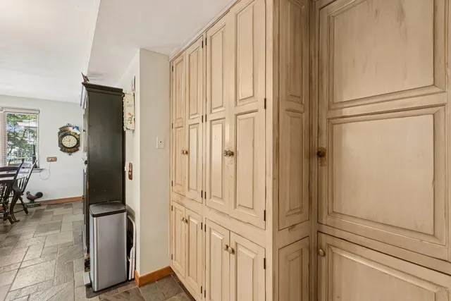 a view of a hallway with wooden floor and furniture