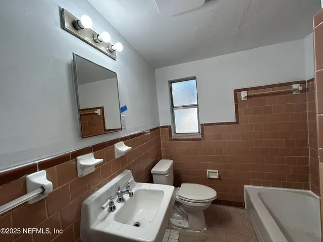 a bathroom with a toilet a sink and mirror