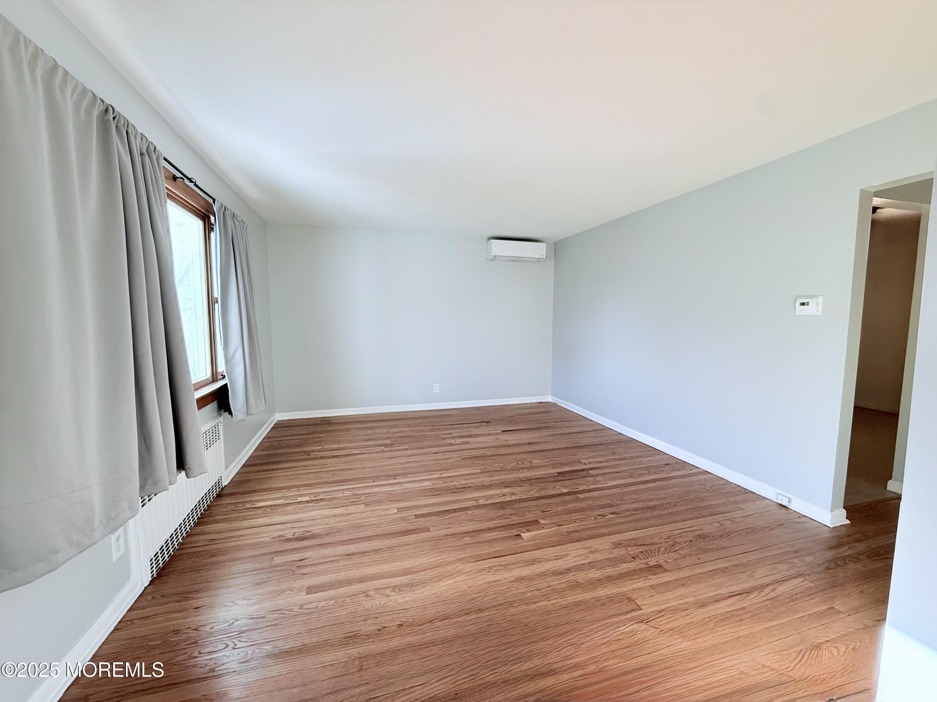 48 Broughton Avenue Bloomfield, NJ 07003 - Photo 2 of 27 wooden floor in an empty room with a window