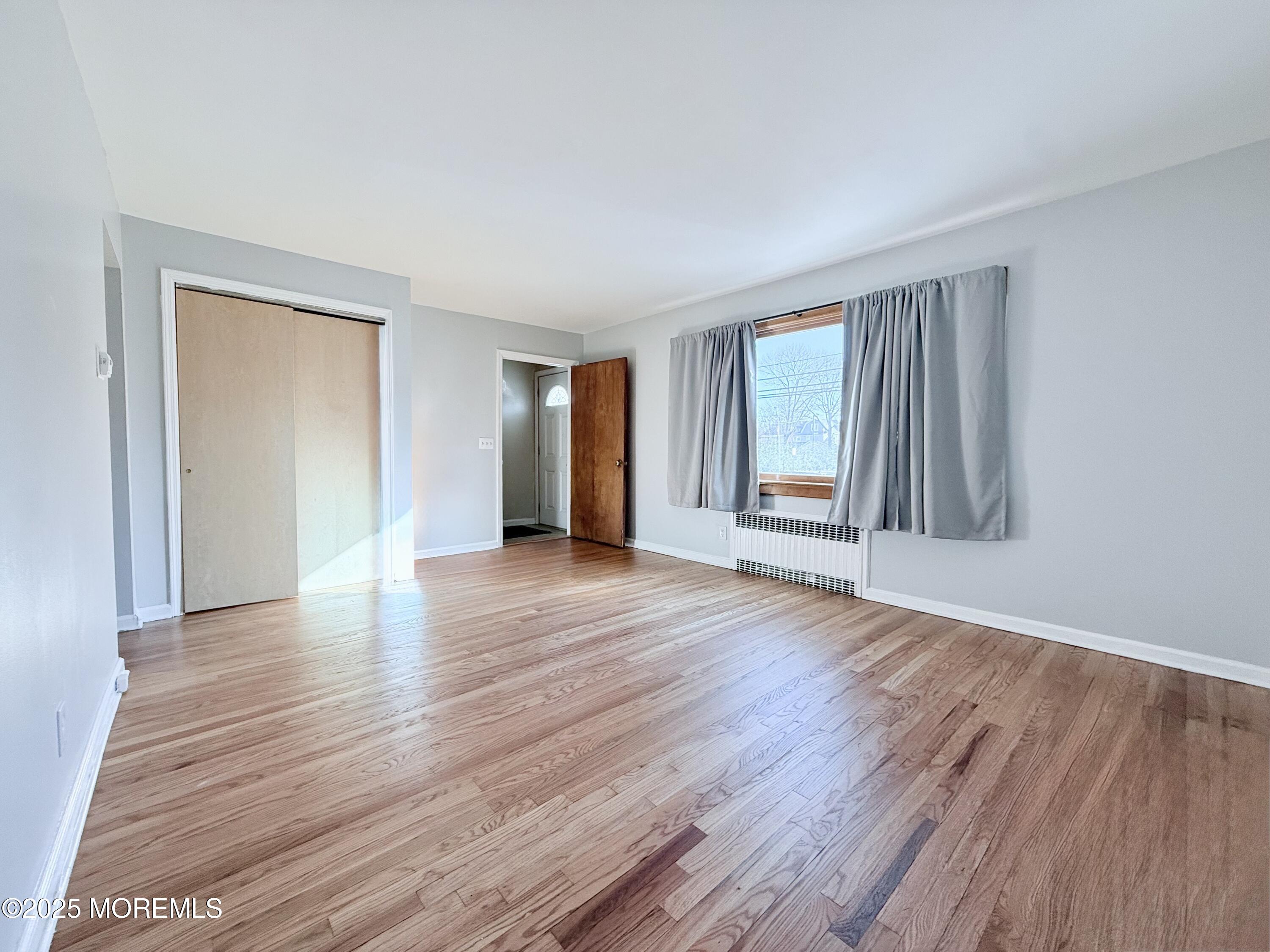 48 Broughton Avenue Bloomfield, NJ 07003 - Photo 5 of 27 a view of an empty room with wooden floor and a window