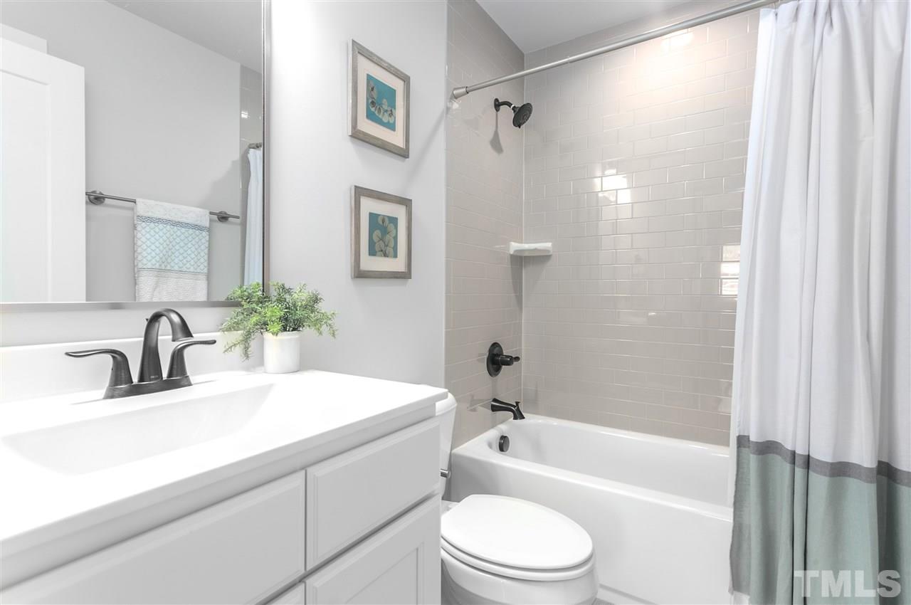 12 Hill Street Raleigh, NC 27610 - Photo 23 of 30 a bathroom with a sink a toilet a tub and shower