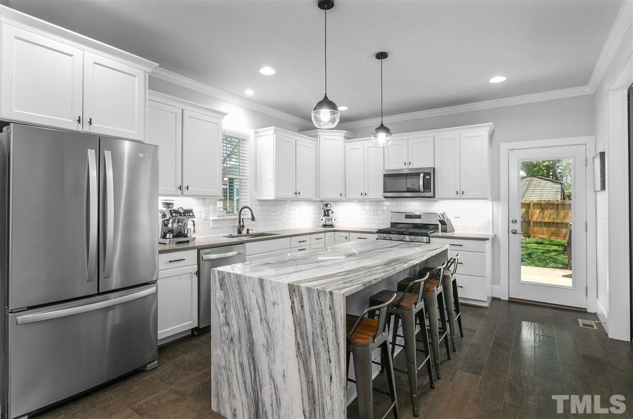 12 Hill Street Raleigh, NC 27610 - Photo 8 of 30 a kitchen with stainless steel appliances granite countertop a refrigerator a sink dishwasher a stove and white countertops with wooden floor