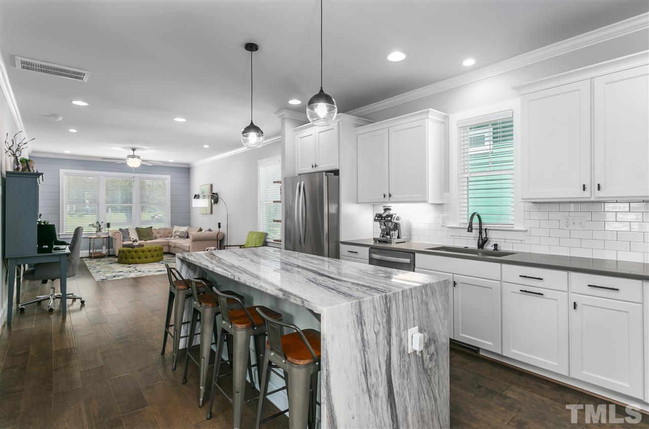 12 Hill Street Raleigh, NC 27610 - Photo 10 of 30 a kitchen with stainless steel appliances kitchen island granite countertop a table chairs sink and cabinets