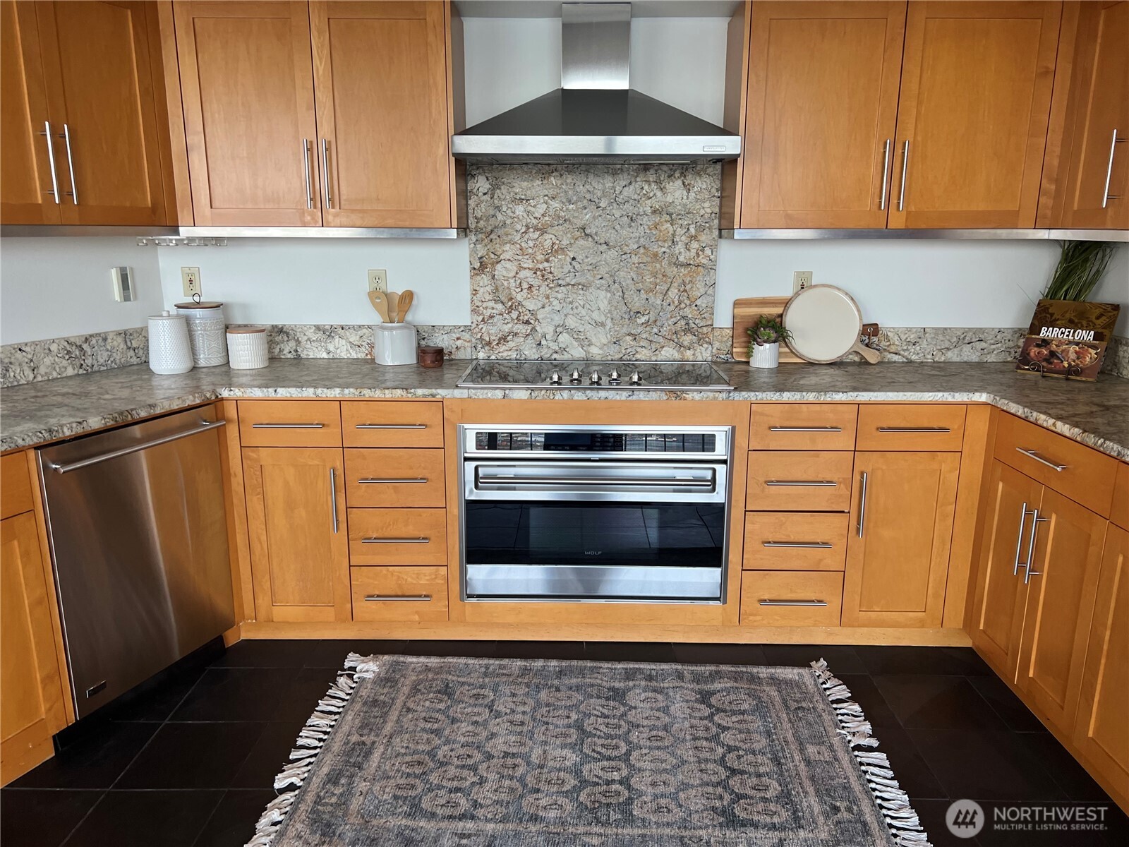 1 North Stadium Way, Unit 16 Tacoma, WA 98403 - Photo 16 of 39 a kitchen with granite countertop a stove top oven microwave and cabinets