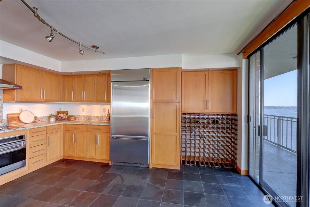 1 North Stadium Way, Unit 16 Tacoma, WA 98403 - Photo 17 of 39 a kitchen with granite countertop a refrigerator and a stove top oven