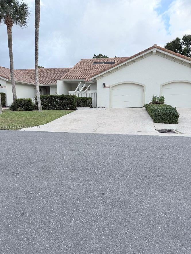 a view of a house with a yard and palm trees