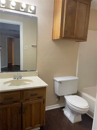 a bathroom with a toilet a sink and mirror